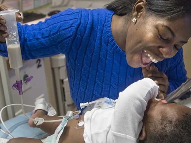 Mother smiling at her NICU baby