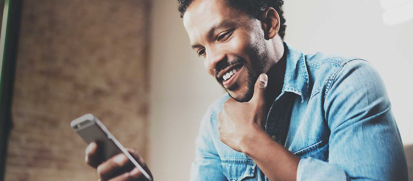 Person smiling while looking at their cellphone