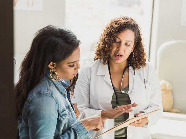 Healthcare provider talking to woman.