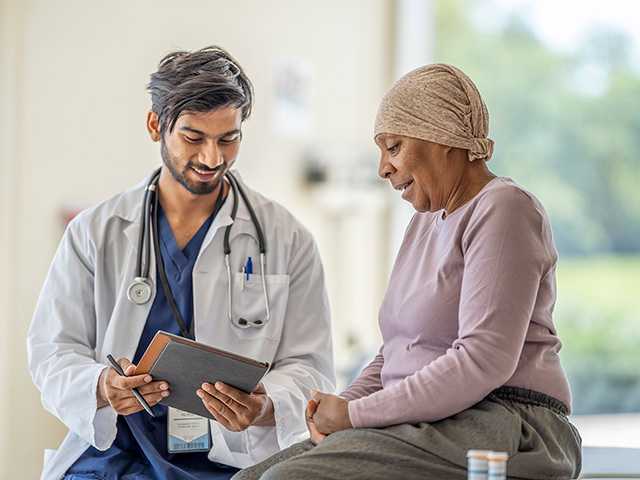 Provider talking to woman in scarf