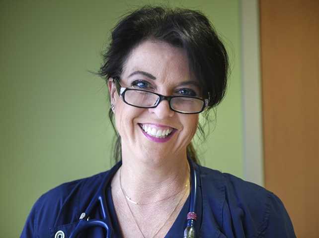 Woman with glasses and short brown hair smiling